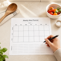 Weekly meal planner on a table with kitchen items
